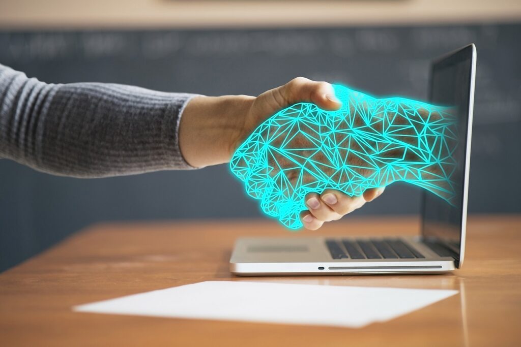 Human hand handshaking an AI hand through the laptop